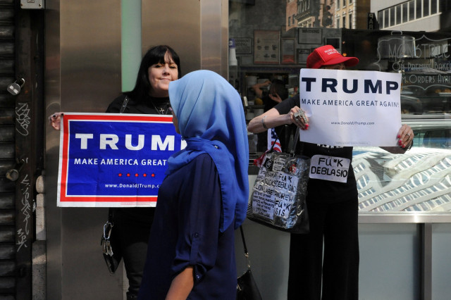 a woman wearing a muslim headscarf walks past people holding u s republican presidential nominee donald trump signs before the annual muslim day parade in the manhattan borough of new york city september 25 2016 reuters stephanie keith file photo a woman wearing a muslim headscarf walks past people holding u s republican presidential nominee donald trump signs before the annual muslim day parade in the manhattan borough of new york city september 25 2016 reuters stephanie keith file photo