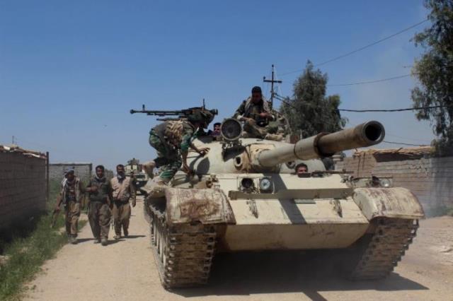 kurdish peshmerga forces sit on top of a tank on the outskirts of kirkuk april 18 2015 photo reuters