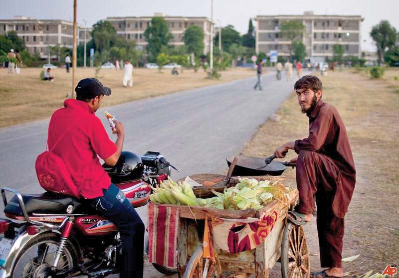 a motorcyclist has some piping hot corn on the cob photo file