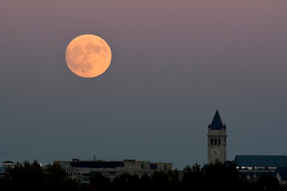 the moon rises behind the espa a building in madrid on november 13 2016 on the eve of a quot supermoon quot photo afp