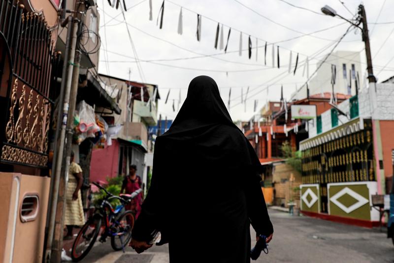 a woman wearing a hijab walks through a street near st anthony s shrine in colombo sri lanka photo reuters