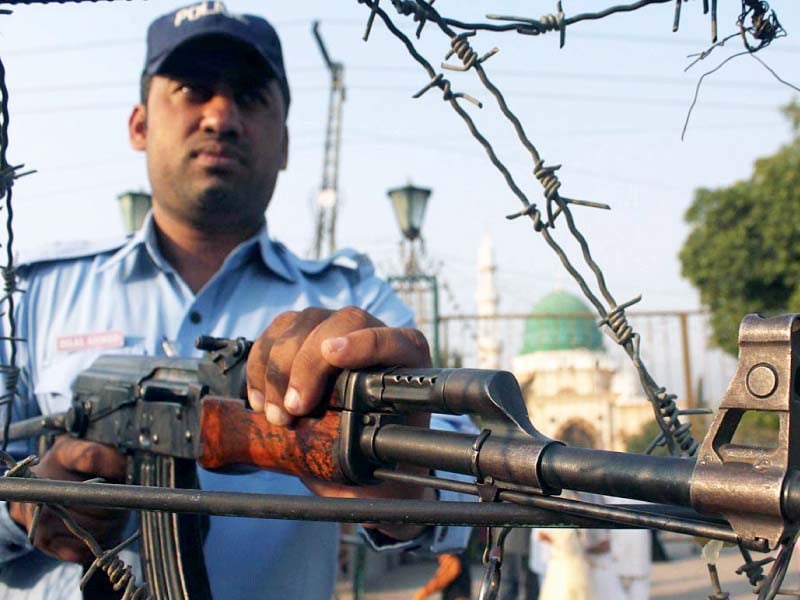 a policeman stands guard at the bari imam shrine photo online