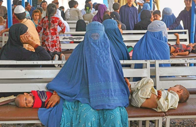 an afghan refugee woman waits with her children to register at the unhcr office photo file an afghan refugee woman waits with her children to register at the unhcr office photo file