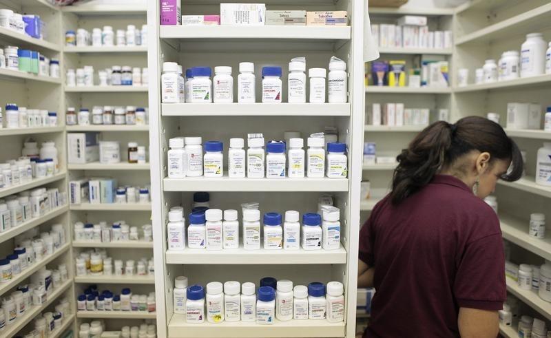 a pharmacy employee looks for medication as she works to fill a prescription while working at a pharmacy in new york photo reuters