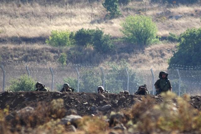 israeli soldiers take positions near the border between syria and the israeli occupied golan heights as seen from the syrian village of beer ajam in the quneitra governorate july 10 2016 picture taken july 10 2016 photo reuters