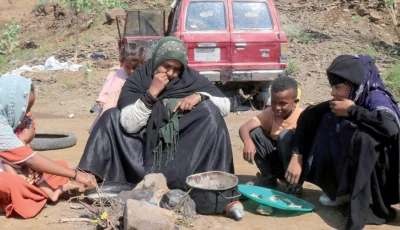 a displaced woman eats with her children at a makeshift camp for displaced people in taiz province yemen photo reuters