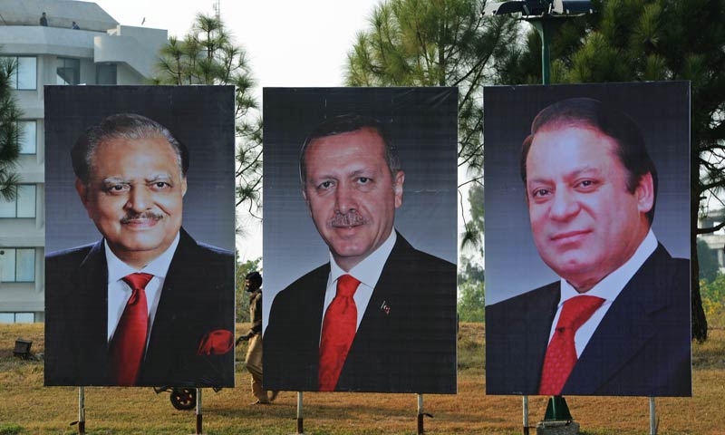 a pakistani labourer works alongside portraits of pakistan president mamnoon hussain l pakistan prime minister nawaz sharif r and visiting turkish prime minister recep tayyip erdogan c on constitution avenue in islamabad on december 22 2013 erdogan is scheduled to pay a two day official visit to pakistan from december 23 to discuss economic co operation between the two countries afp photo farooq naeem