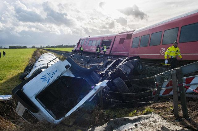 a policeman walks near a derailed passenger train and a smashed milk tanker after a crash near winsum photo afp