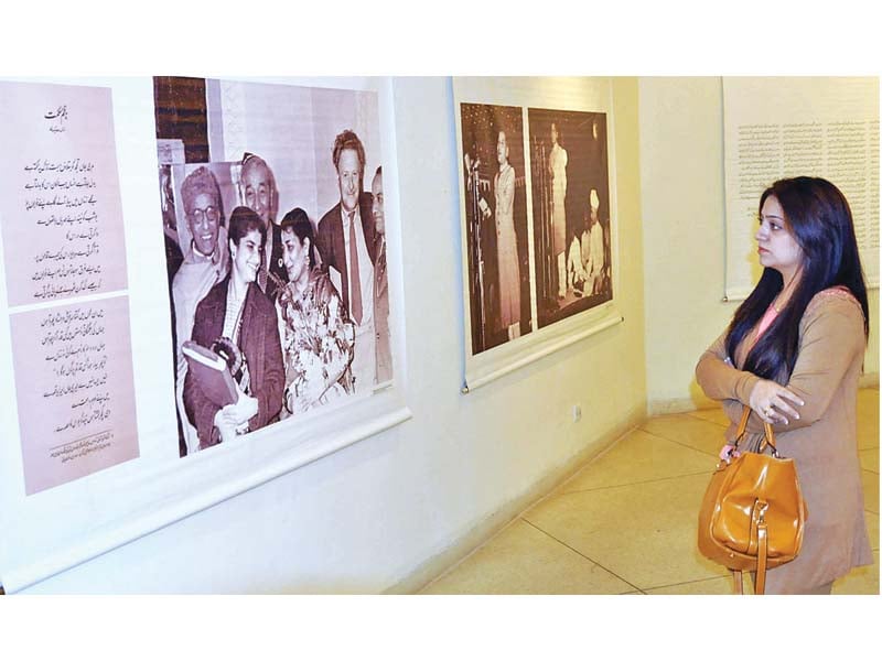 a woman admires artworks on display at alhamra for faiz international festival photo app