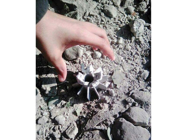 a man picks up part of a mortar shell fired by indian forces in bhimber sector of loc photo online a man picks up part of a mortar shell fired by indian forces in bhimber sector of loc photo online