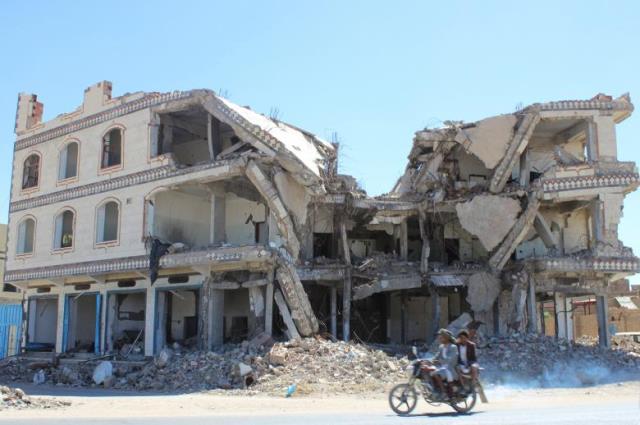 people ride a motorbike in front of a building destroyed by a recent saudi led air strike in the northwestern city of saada yemen november 16 2016 photo reuters