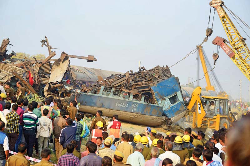 indian rescue workers search for survivors in the wreckage of a train that derailed near pukhrayan in kanpur district on sunday photo afp