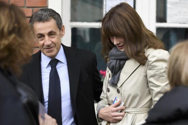 nicolas sarkozy l former french president and candidate for the french conservative presidential primary and his wife carla bruni sarkozy speak to a women outside a polling station in the first round of the french center right presidential primary election vote in paris photo reutersl