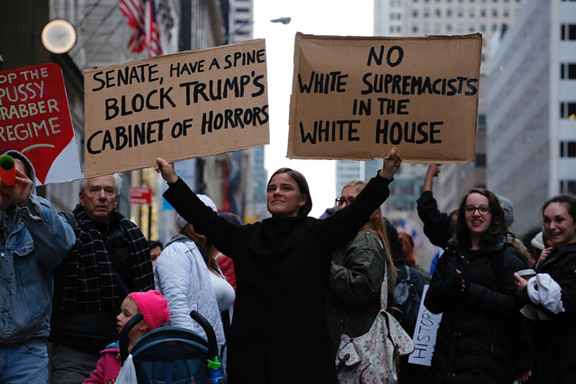 a woman protests against us president elect donald trump in front of trump tower on november 20 2016 in new york photo afp