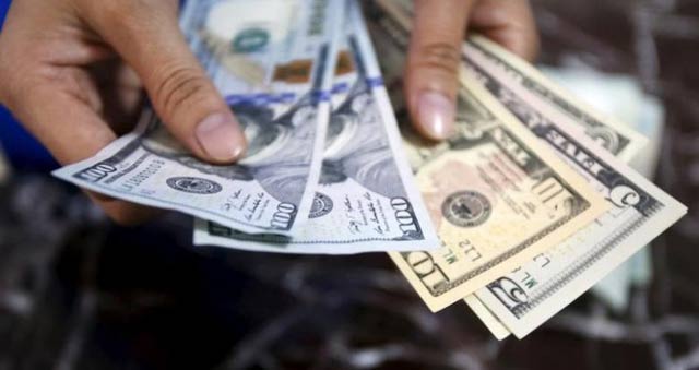 an employee checks u s dollar bank notes at a bank in hanoi vietnam photo reuters