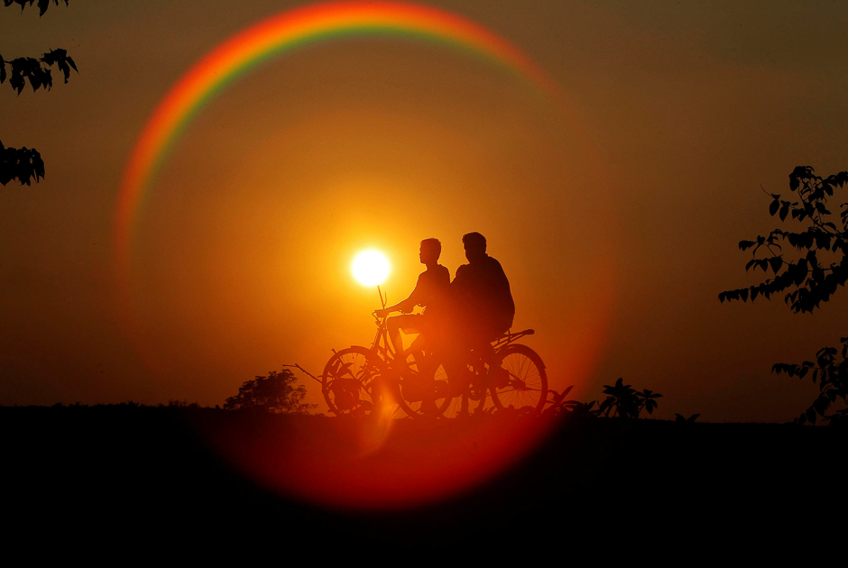 boys are silhouetted against the setting sun as they ride bicycles on the outskirts of agartala india photo reuters