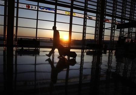 a traveller walks to his flight at ronald reagan national airport as the sun rises in washington september 24 2008 reuters jason reed