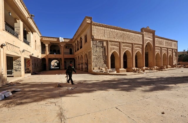 a member of the iraqi christian forces kataeb babylon babylon brigades walks in the courtyard of the mar benham syriac catholic monastery in the town of khidr ilyas southeast of mosul on november 22 2016 photo afp