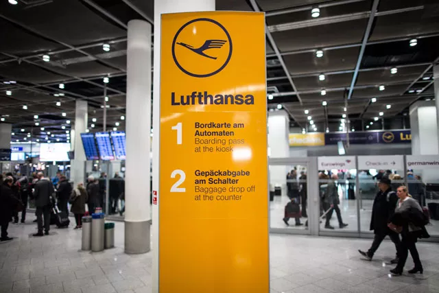 flight passengers walk past an information sign with the logo of german airline lufthansa on november 25 2016 at the airport in duesseldorf western germany photo afp flight passengers walk past an information sign with the logo of german airline lufthansa on november 25 2016 at the airport in duesseldorf western germany photo afp