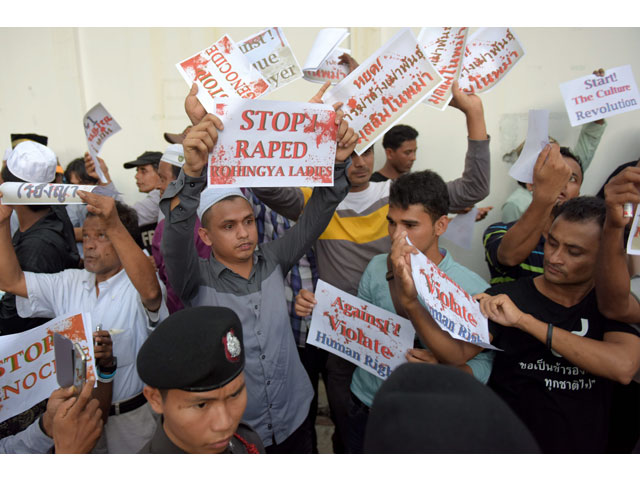 muslims protesters hold messages in the air in front of thai police officials during a protest out side the myanmar embassy in bangkok on november 25 2016 photo afp