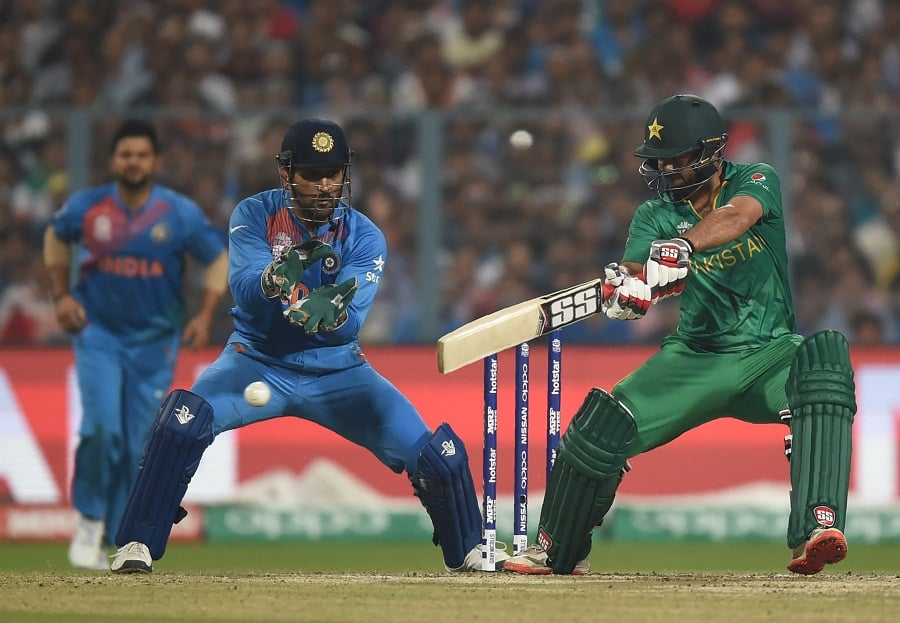 ahmad shahzad r plays a shot as mahendra singh dhoni looks on photo afp