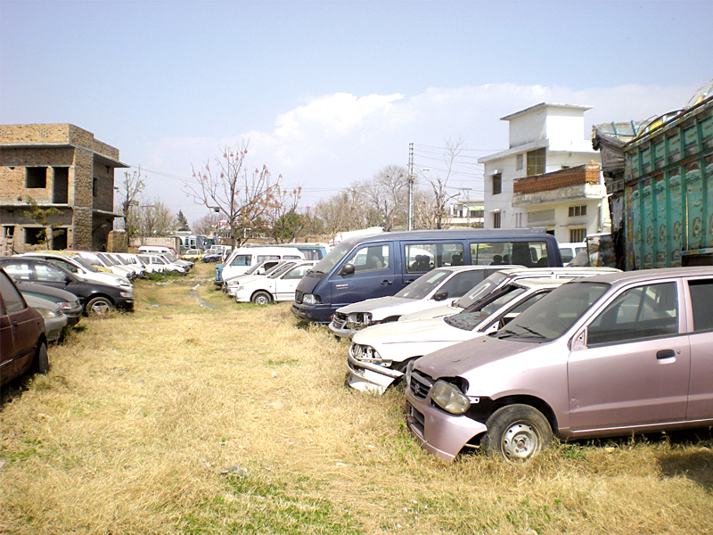 the impound lot featuring cars which all seems to have been stripped for parts or generally ignored photo mudassir raja