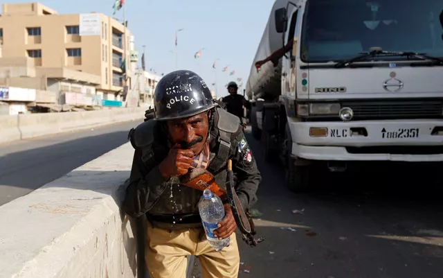 a policeman washes away the effects of tear gas fired by police after shias blocked the main national highway and railway tracks to protest the detention of their religious workers in karachi november 7 2016 photo reuters a policeman washes away the effects of tear gas fired by police after shias blocked the main national highway and railway tracks to protest the detention of their religious workers in karachi november 7 2016 photo reuters