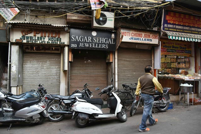 in this photograph taken on november 18 2016 an indian man walks past closed jewelry shops in new delhi photo afp