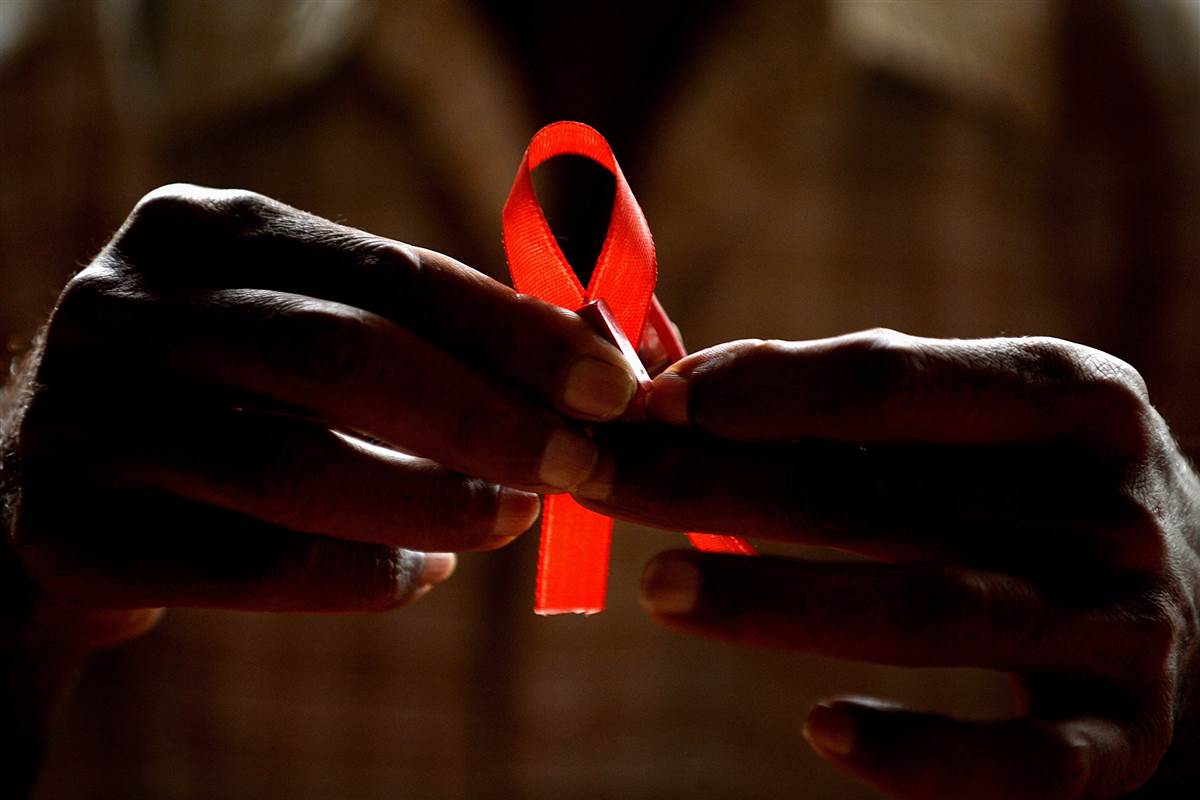 a man holds a red ribbon to mark world aids day at the entrance of emilio ribas hospital in sao paulo december 1 2014 photo reuters