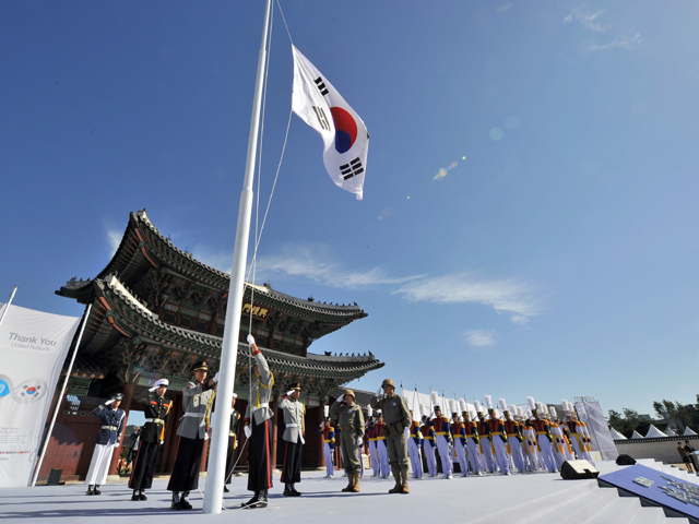 south korean honour guards hoist the national flag to celebrate the recapture of its capital from north korea in a ceremony marking the 60th anniversary of the 1950 53 korean war at the gyeongbok palace of the joseon dynasty in seoul photo afp