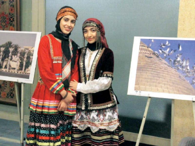 two girls decked out in traditional dresses pose for a photograph at the lok virs photo inp two girls decked out in traditional dresses pose for a photograph at the lok virs photo inp
