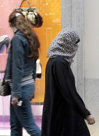 a muslim woman passes a shop with her face covered according to clinton more than a billion people live under governments that suppress religious freedom photo reuters file