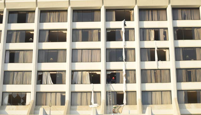 fire fighters look from a room of regent plaza hotel following a fire in the pakistan 039 s port city of karachi on december 5 2016 photo afp