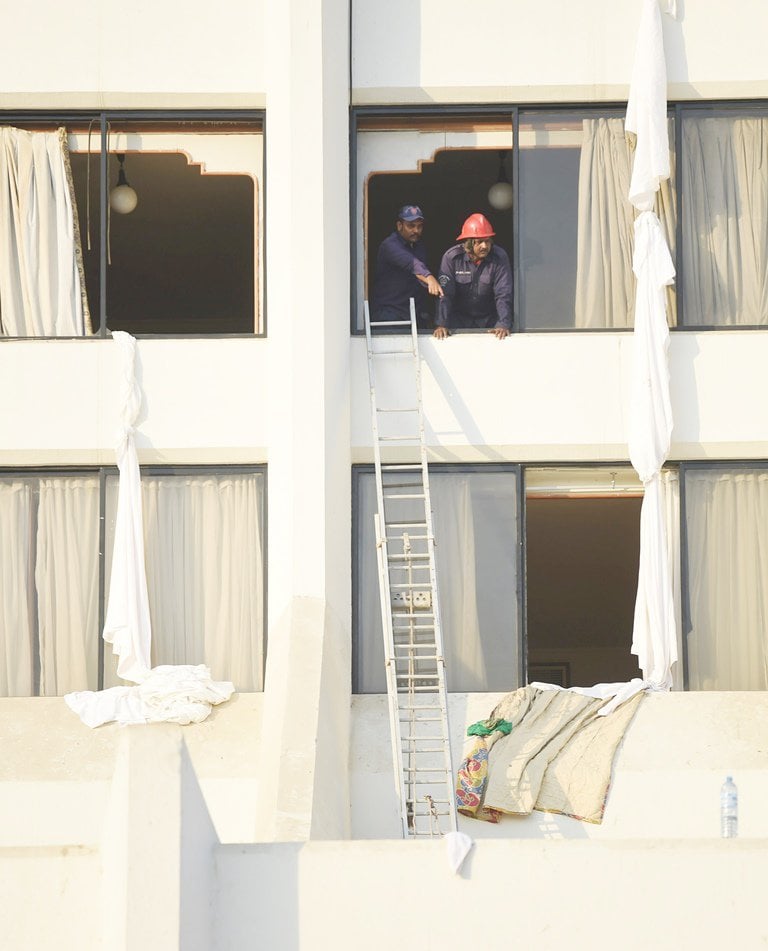 pakistani fire fighters look from a room of regent plaza hotel following a fire in karachi on december 5 2016 photo afp