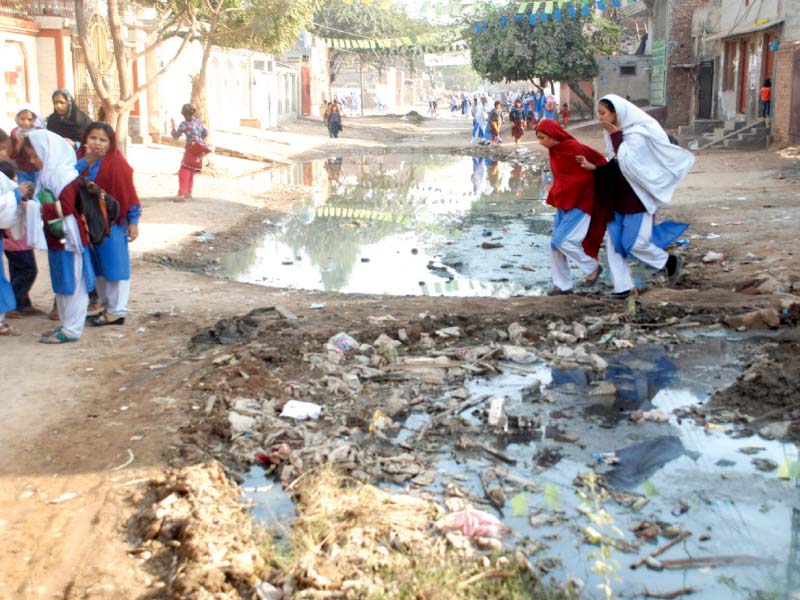 schoolchildren pass through sewage accumulated in an area in sargodha photo online