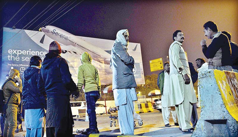 people stand outside the airport in rawalpindi waiting for any news about their relatives who perished in the air crash photo app