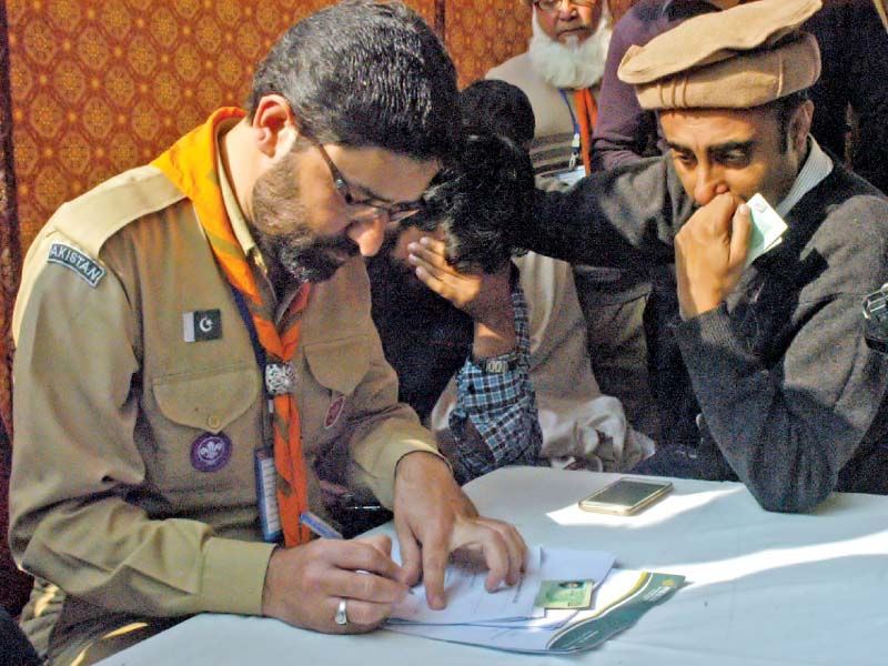 names of crash victims are posted on a hospital wall in abbottabad l while relatives give their details for dna verification at pims in islamababd photo afp waseem nazir express