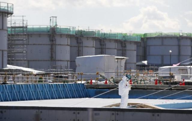 a worker wearing protective suits and masks takes notes in front of storage tanks for radioactive water at tokyo electric power co 039 s tepco tsunami crippled fukushima daiichi nuclear power plant in okuma town fukushima prefecture japan february 10 2016 photo reuters