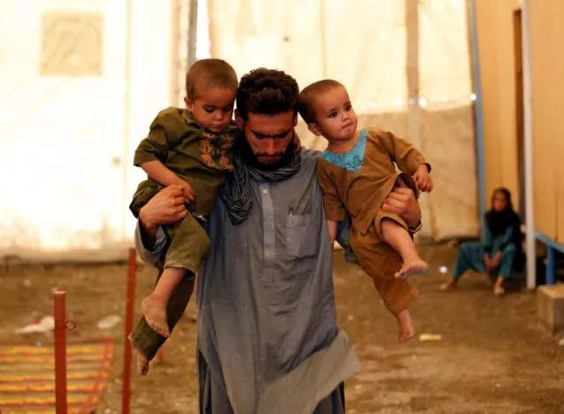 an afghan man holds his children after arriving at a united nations high commissioner for refugees unhcr photo reuters an afghan man holds his children after arriving at a united nations high commissioner for refugees unhcr photo reuters