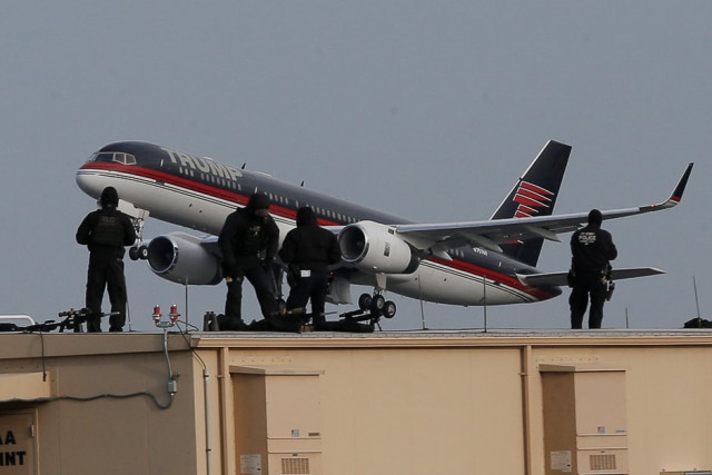 law enforcement personnel look on from a rooftop while us president elect donald trump 039 s plane takes off as trump is travelling to ohio from laguardia airport in new york city us photo reuters