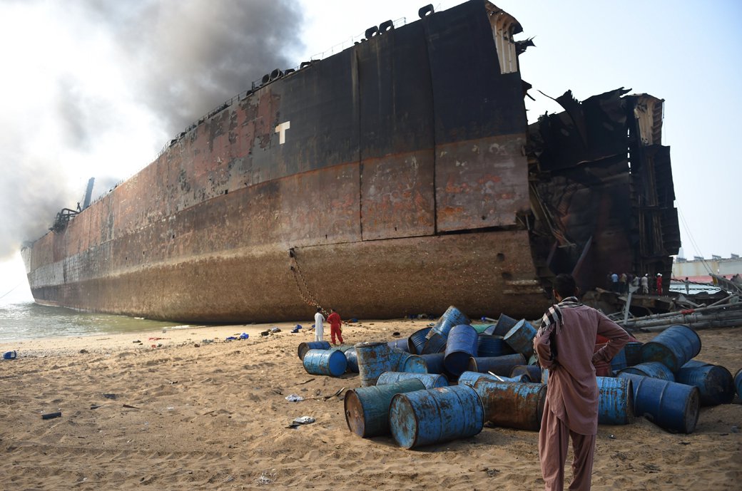 a man looks at the wreckage of a burning ship a day after a gas cylinder explosion at the gadani shipbreaking yard on november 2 2016 photo afp