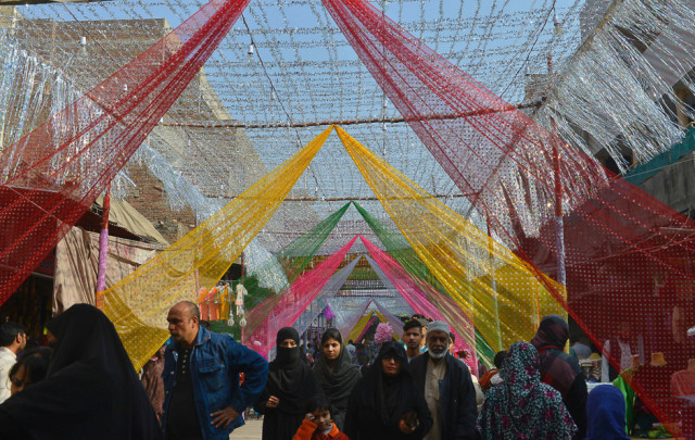 pakistani people walk through a decorated market on the celebration of the religious event in lahore photo afp
