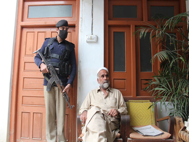 swat valley shopkeeper abdur rahim speaks with a reuters correspondent as one of police bodyguards stands guard over him at his home in mingora pakistan november 22 2016 photo reuters