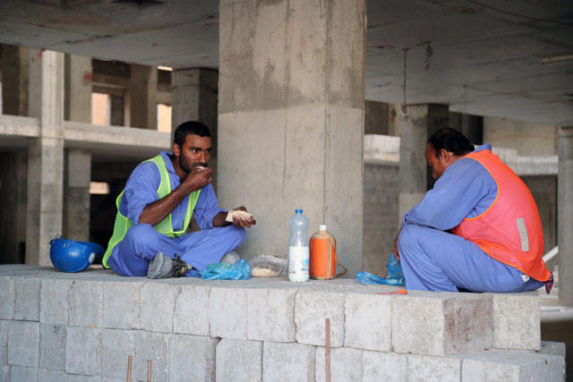 migrant workers eat during a break at a construction site in the qatari capital doha on december 6 2016 photo afp migrant workers eat during a break at a construction site in the qatari capital doha on december 6 2016 photo afp