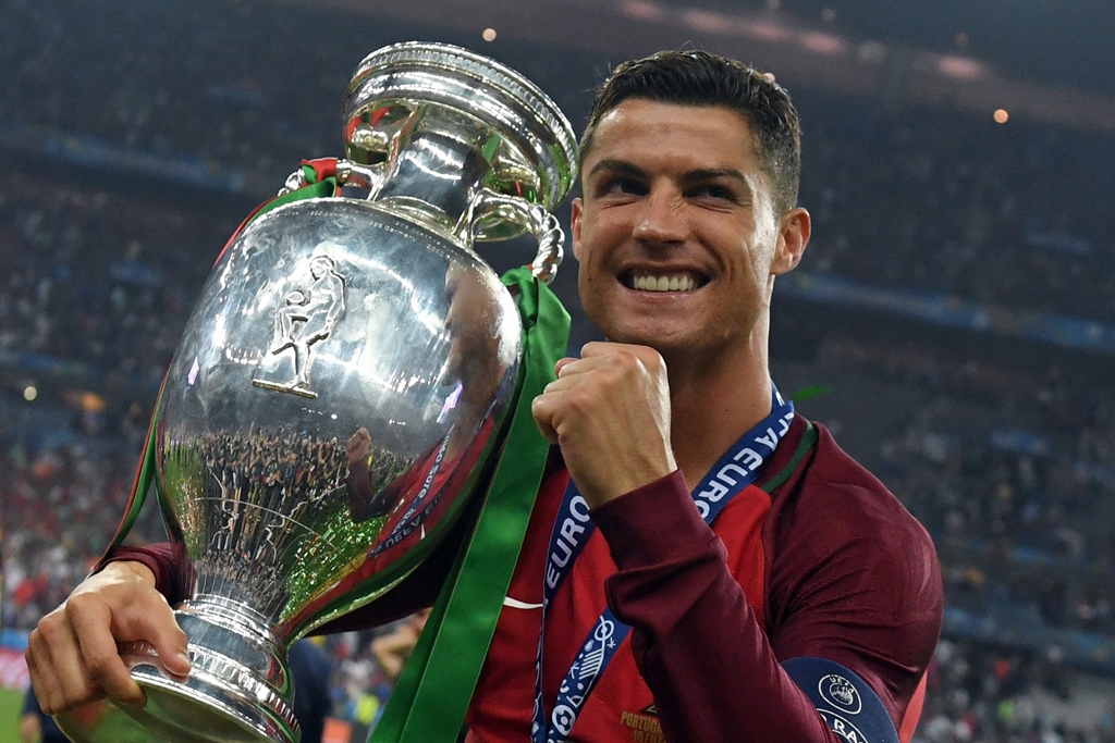 cristiano ronaldo smiling while posing with the trophy after portugal won the euro 2016 final at the stade de france in paris photo afp