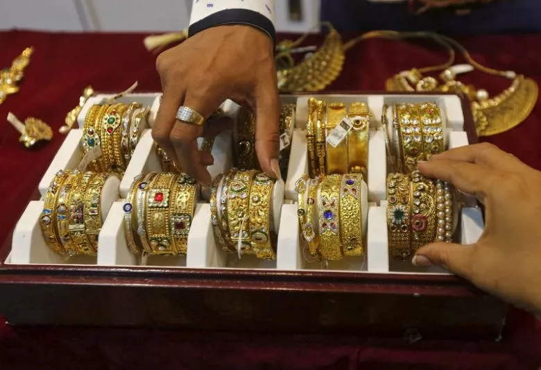 a salesman helps a customer r to select gold bangles at a jewelry showroom in mumbai india may 21 2015 photo reuters