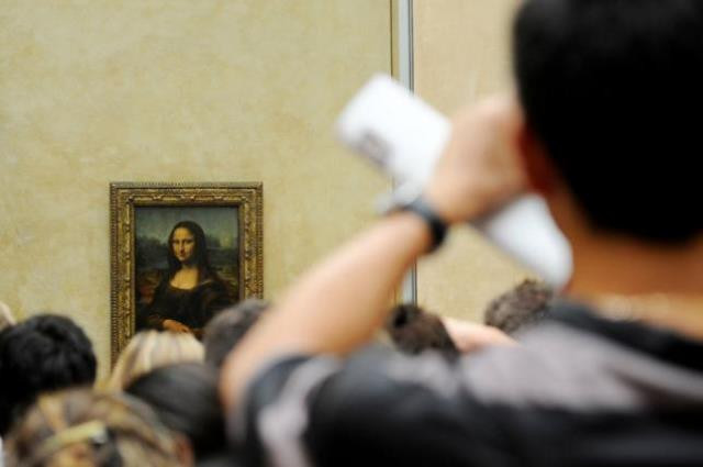 a tourist takes souvenir photos of italian painter leonardo da vinci 039 s famed portrait mona lisa photo reuters a tourist takes souvenir photos of italian painter leonardo da vinci 039 s famed portrait mona lisa photo reuters