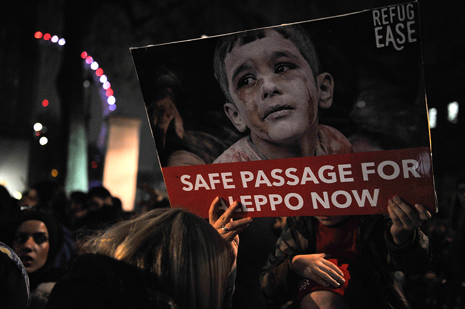 protesters hold placards during a demonstration in solidarity with the enhabitants of the embattled syrian city of aleppo outside the entrance to downing street in central london photo afp