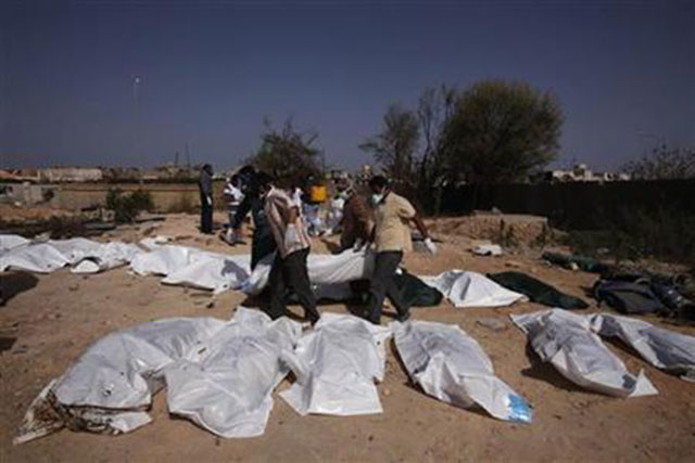 volunteers carry a body as they try to identify 26 exhumed bodies found in unknown graves photo reuters