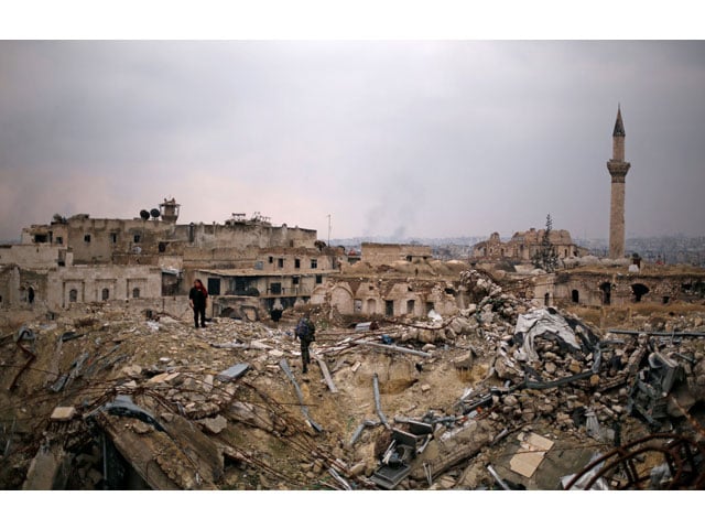 a member of forces loyal to syria 039 s president bashar al assad stands with a civilian on the rubble of the carlton hotel in the government controlled area of aleppo syria december 17 2016 photo reuters